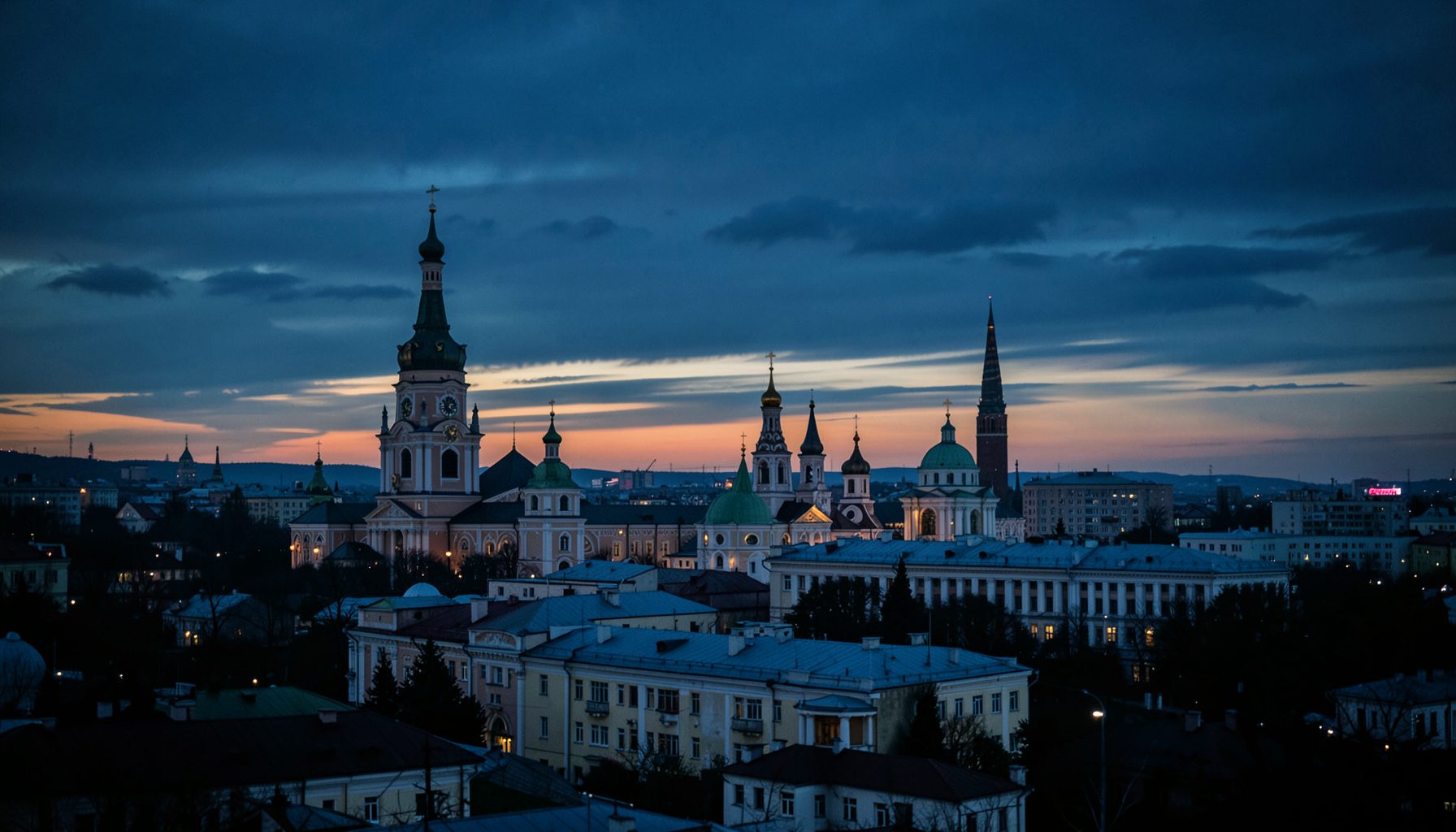 Панорама вечернего города Чернигова с куполами церквей на фоне сумеречного неба, глубокие синие и тёмно-оливковые оттенки